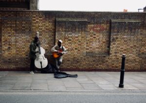 Two musicians performing on the sidewalk, by Tim Bechervaise. From Unsplash.
