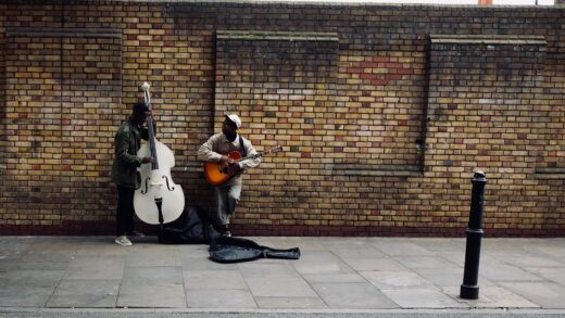 Two musicians performing on the sidewalk, by Tim Bechervaise. From Unsplash.