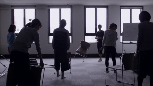People trying to balance chairs