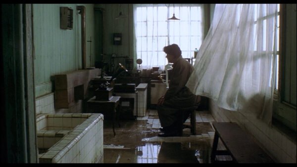 Detective Takabe listens to an ancient recording, from the 1997 Kiyoshi Kurasawa film "Cure"
